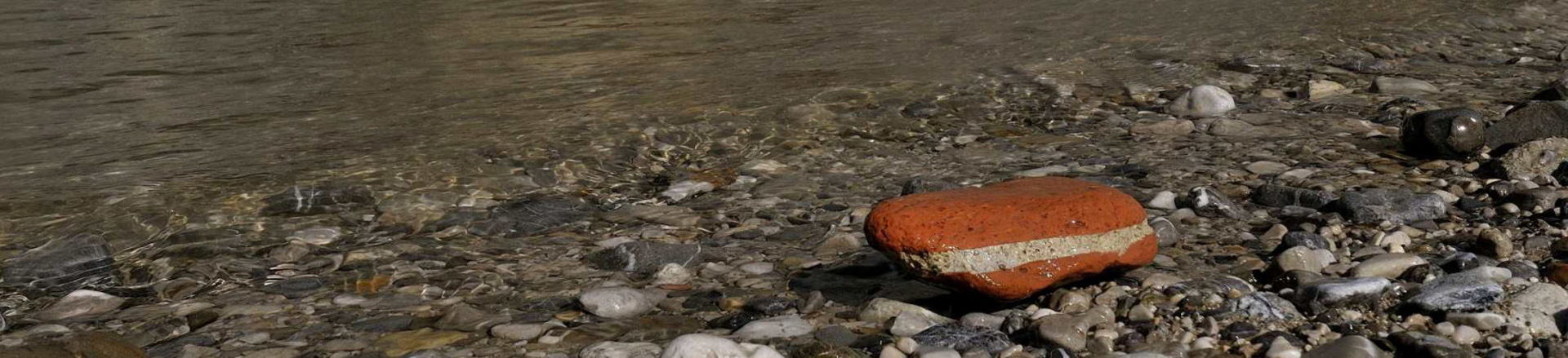 Rot-weiß-roter, zu einem Kieselstein geschliffener Mauerteil in der Erlaufschlucht 