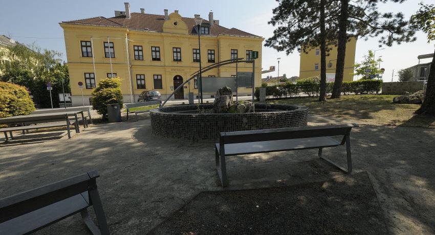 Wasserbecken und Sitzbänke mit Blick auf das Gemeindeamt